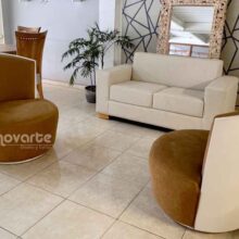 Sala moderna con sofá minimalista de 2 puestos color beige y sillas Ágata en poliuretano blanco, ubicada en showroom Innovarte. Estilo minimalista calido. Warm minimalist