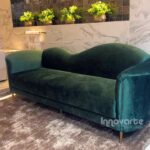 Sofá tipo diván tapizado en terciopelo verde, con diseño elegante y moderno