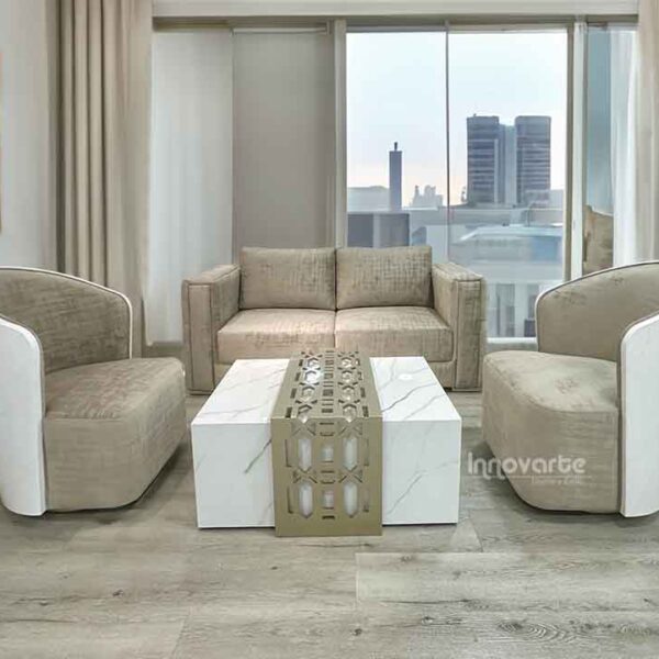Sala moderna con sofá Golden beige y dos sillas Holandesas giratorias en tapizado claro, mesa central con terminado marmolizado blanco y detalles en madera calada pintado en poliuretano champaña.