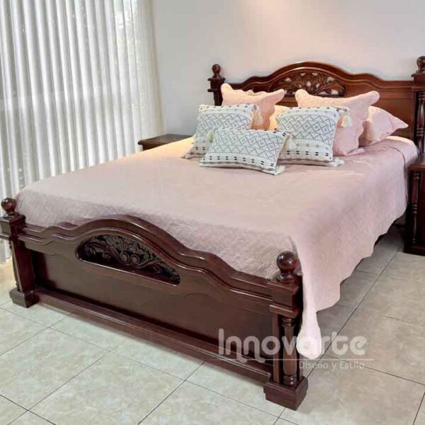 Cama clásica de madera tallada con mesas de noche en habitación iluminada – Innovarte