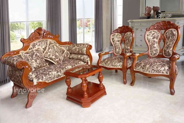 Sala clásica con sofá y sillas de madera talladas, creando un ambiente elegante y atemporal