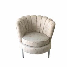 Poltrona tapizada en tela suave, con diseño ergonómico y patas metálica, ideal para salas elegantes