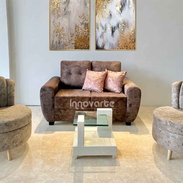 Sofá pequeño tapizado en color café acompañado de dos sillas estilo shell tapizadas en beige, creando un ambiente acogedor y elegante en la sala