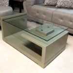 Mesa de centro con terminado en poliuretano ámbar y superficie de vidrio, ideal para añadir un toque moderno y elegante a tu sala