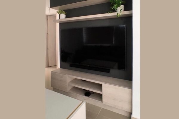 Mueble de TV en tonos cálidos con estantes para organizar cables y dispositivos electrónicos