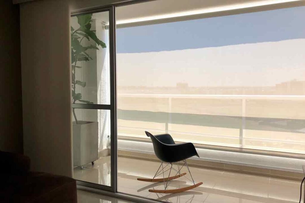 Toldo vertical instalado en un balcón, ofreciendo privacidad y protección solar, con un diseño elegante y moderno