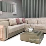 Sofá modular en forma de L tapizado en tela beige, ideal para espacios modernos y versátiles