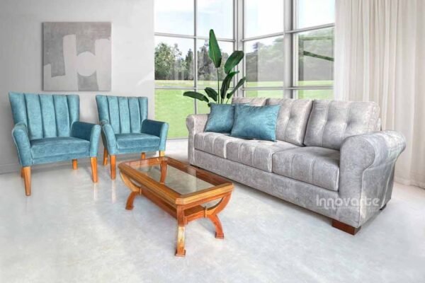 Sala con sofá y sillas tapizadas en tela turquesa, decorados con cojines coloridos y una mesa de centro de madera