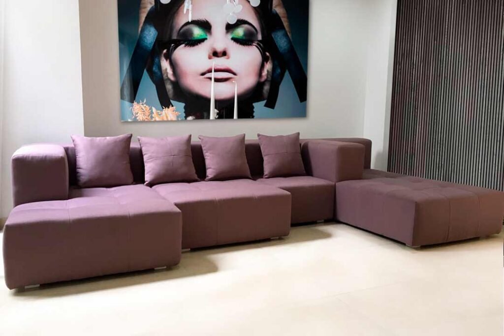 Sofá modular en forma de L tapizado en tela vibrante, ideal para espacios modernos y versátiles