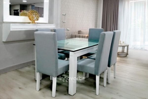 Comedor con cubierta en vidrio y sillas tapizadas en gris y pintadas en poliuretano