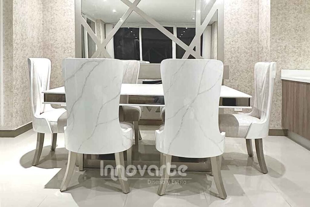 Comedor con mesa de madera marmolizada y sillas tapizadas en beige y pintadas en poliuretano