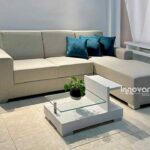 Sofá modular en forma de L tapizado en tela gris, ideal para espacios modernos y versátiles