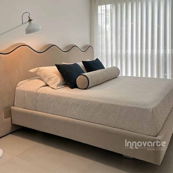 Alcoba moderna con cama tapizada y cabecero en forma de ondas, destacando un diseño moderno y elegante