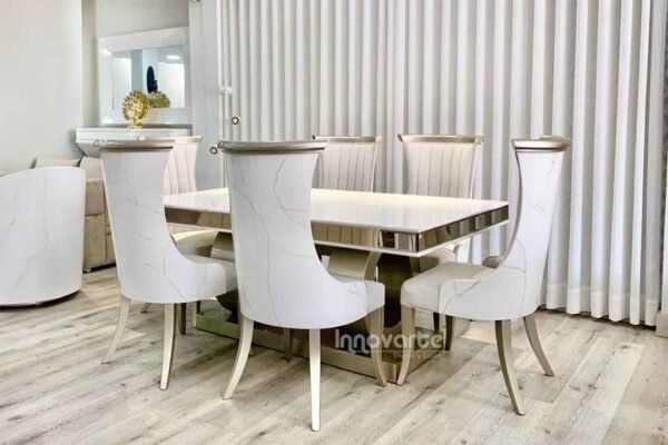 Comedor con mesa de madera marmolizada y sillas tapizadas en beige y pintadas en poliuretano