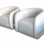 juego de Sillas decorativas modernas estilo nórdico color gris claro con respaldo curvo, ubicada en un espacio elegante de showroom.
