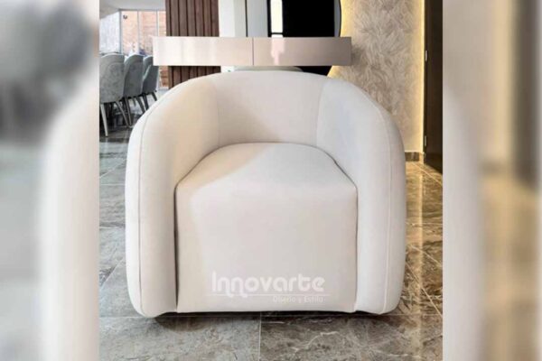 Silla decorativa moderna estilo nórdico color blanco, con respaldo curvo, ubicada en un espacio elegante de showroom.