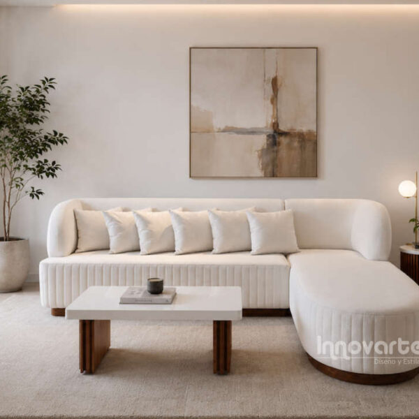 Sala en L Niza de diseño curvo tapizada en velvet color crudo, con base en madera de cedro y mesa de centro con cubierta marmolizada.