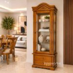 Vitrina clásica mediana elaborada en cedro macizo con talla artesanal, puertas de vidrio, entrepaños de cristal y cajones inferiores, ideal para sala o comedor de estilo clásico.